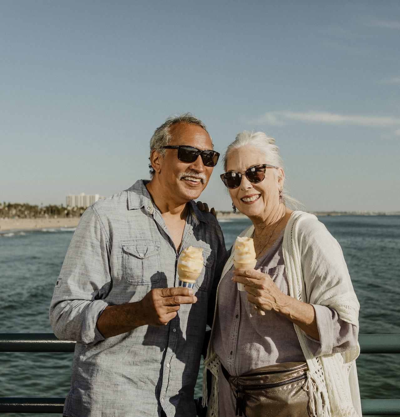 Smiling senior couple with an ice cream cone standing on the Santa Monica Pier